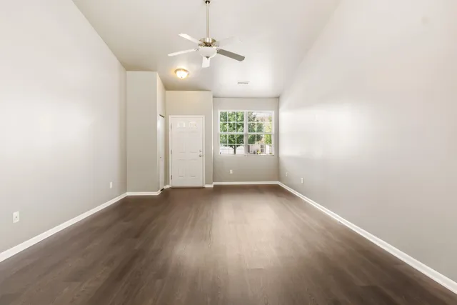 an empty room with wooden floor and windows