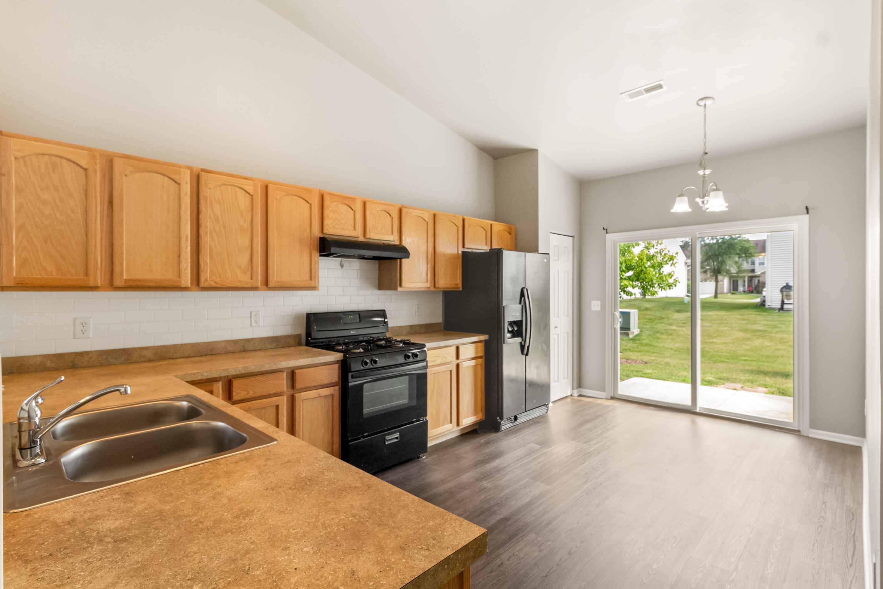 7615 111th Lane Crown Point, IN 46307 - Photo 8 of 19 a kitchen with stainless steel appliances granite countertop a stove a sink and a refrigerator with wooden floor