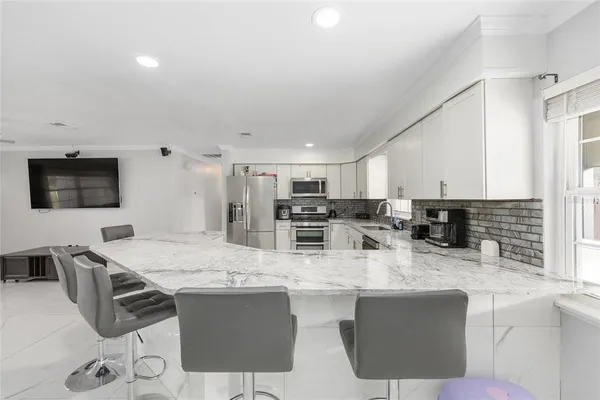 a kitchen with stainless steel appliances granite countertop a sink and a refrigerator