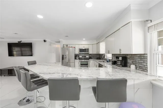 a kitchen with stainless steel appliances granite countertop a sink and a refrigerator