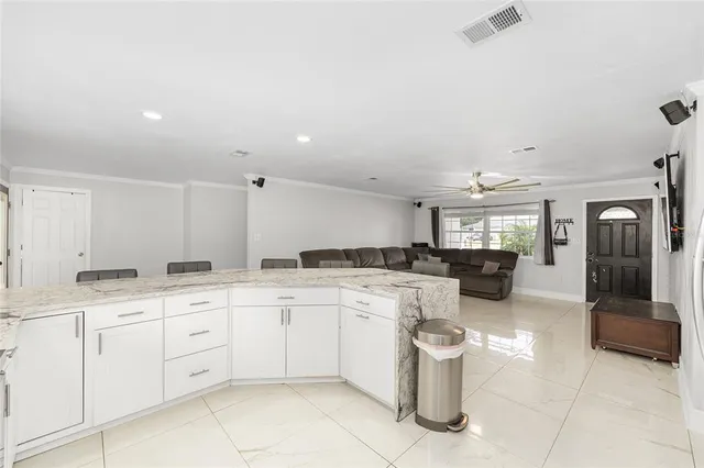 a kitchen with a sink dishwasher a stove and white cabinets with wooden floor