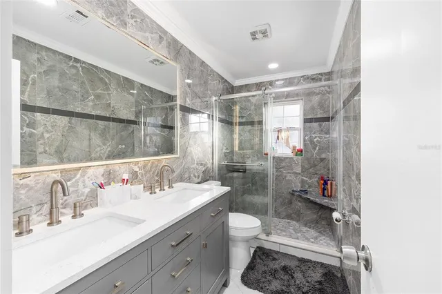 a bathroom with a sink a toilet and shower