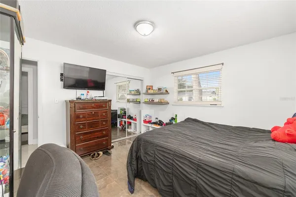 a bedroom with a bed and a flat screen tv