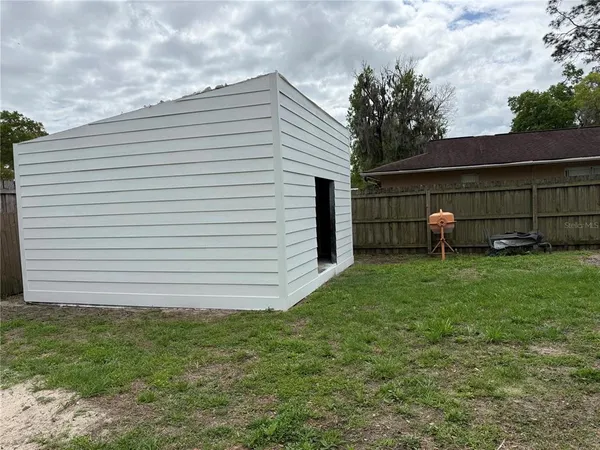 a view of a white house next to a yard