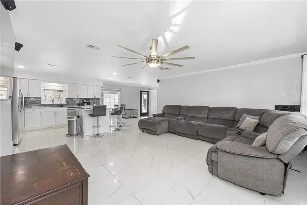 a living room with furniture and kitchen view