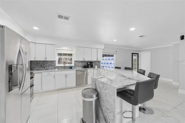 a kitchen with stainless steel appliances granite countertop a stove refrigerator sink and cabinets