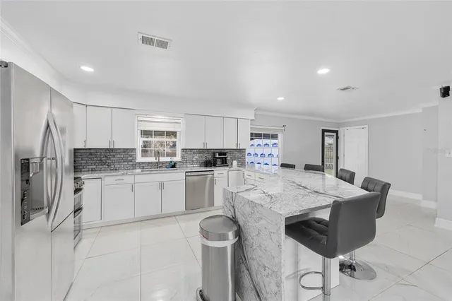 a kitchen with stainless steel appliances granite countertop a stove refrigerator sink and cabinets