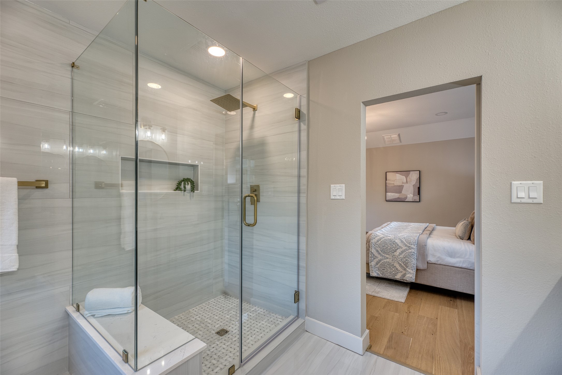 7602 Pagewood Lane Houston, TX 77063 - Photo 24 of 33 Shower includes a bench and marble tile for comfort and style.