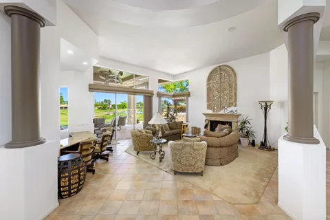 a living room with fireplace furniture and a large window