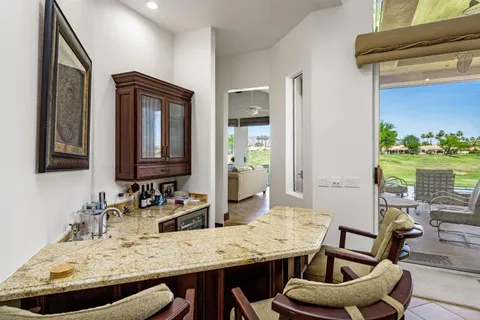 a view of kitchen with granite countertop kitchen island dining table and chairs