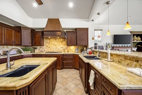 a kitchen with stainless steel appliances granite countertop a sink a stove and cabinets