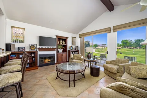 a living room with furniture fireplace and a large window