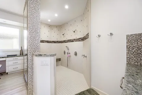 a spacious en suite bathroom with double sink and a large mirror