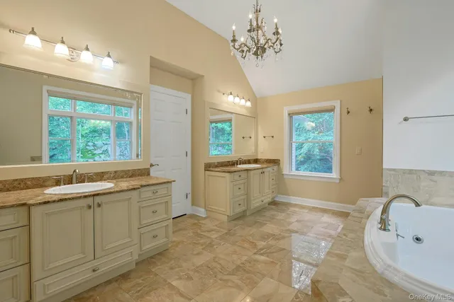 a large bathroom with a tub sink and mirror