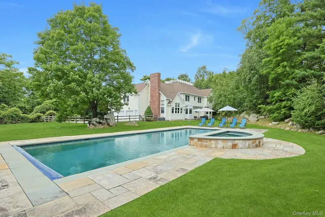 a view of house with garden space and sitting area