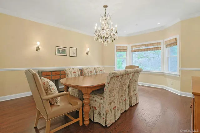 a dining room with furniture a chandelier and wooden floor