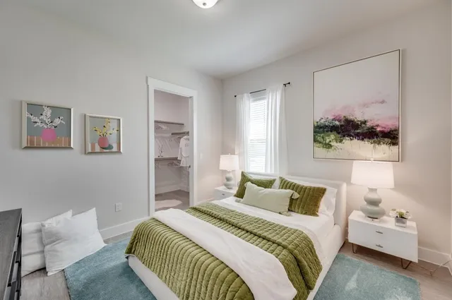 a bedroom with a bed and a painting on the wall