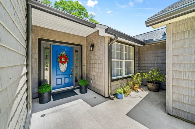 a large kitchen with a large counter top a sink a window and stainless steel appliances