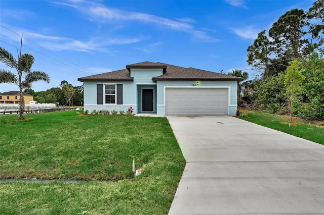 a front view of a house with a garden and yard