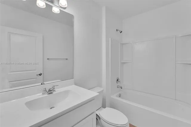a bathroom with a bathtub shower sink vanity and toilet
