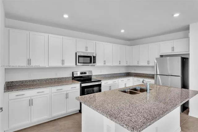 a kitchen with granite countertop a sink and a stove top oven