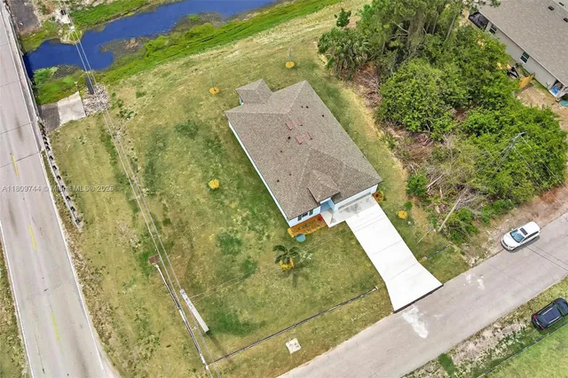 an aerial view of residential houses with outdoor space and trees