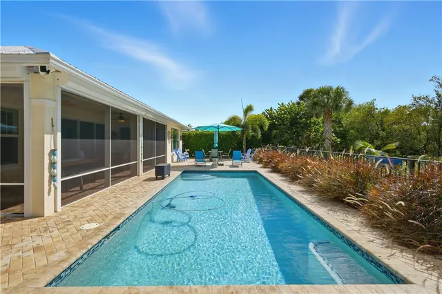 a view of a chairs and table in the patio with a swimming pool