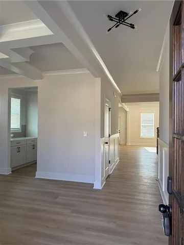 a view of a hallway with wooden floor and staircase