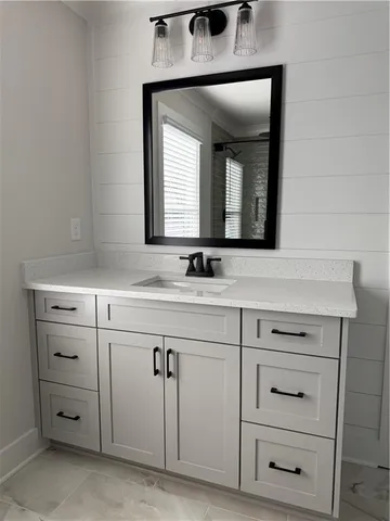 a bathroom with a sink vanity and mirror