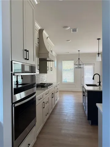 a kitchen with granite countertop a stove a sink and wooden floor