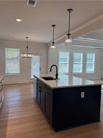 a kitchen with stainless steel appliances granite countertop a sink a stove and a wooden floors