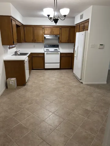 a kitchen with kitchen island granite countertop a sink stove and refrigerator