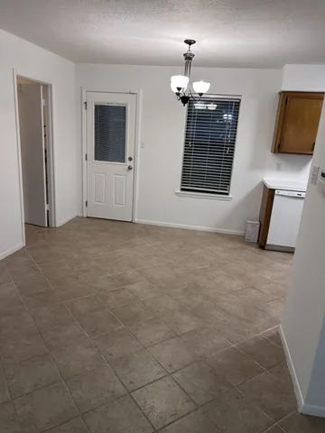 an empty room with windows and fireplace