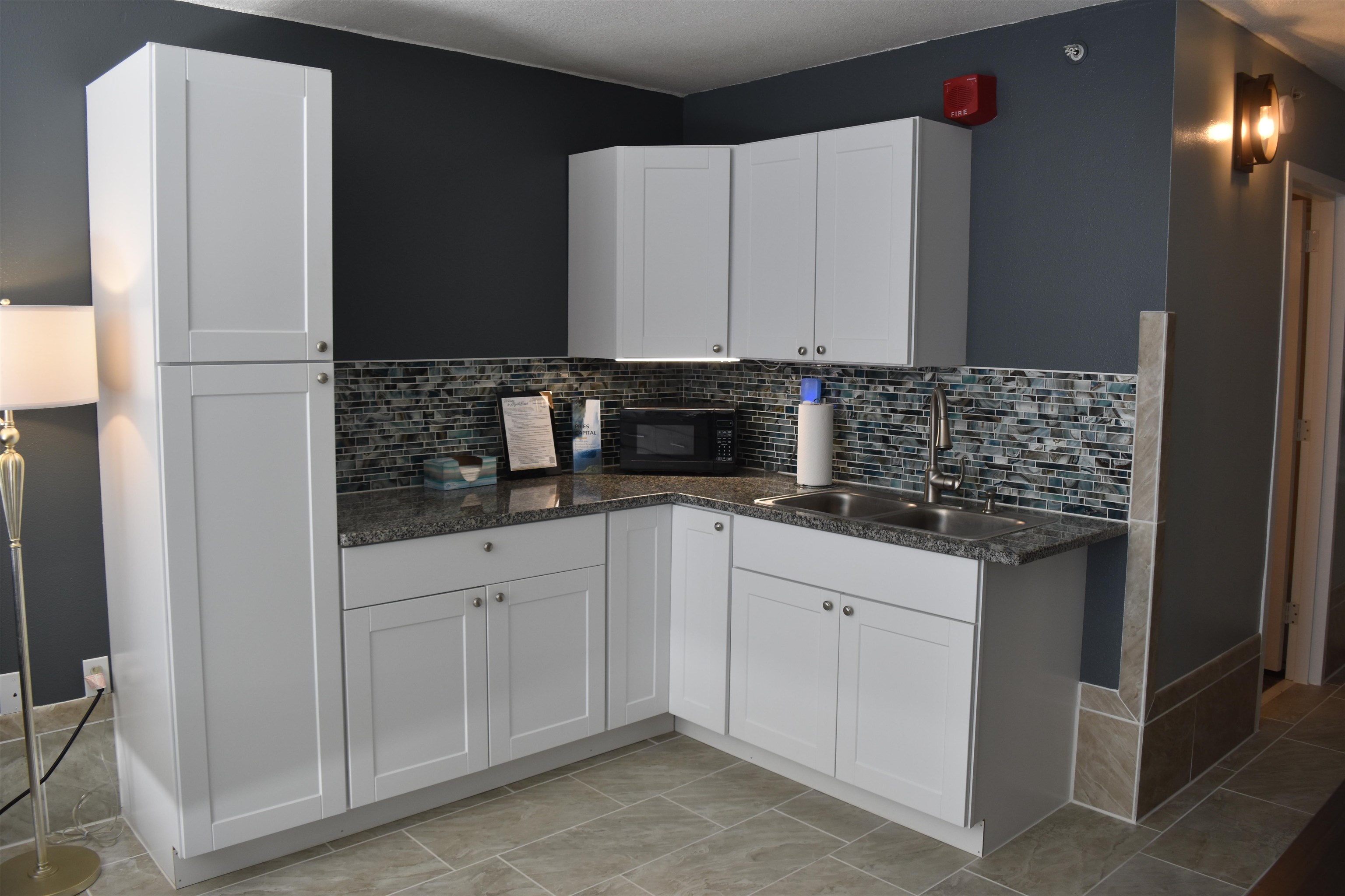 1501 South Ocean Boulevard, Unit 910 Myrtle Beach, SC 29577 - Photo 5 of 31 Kitchen with white cabinets, black microwave, backsplash, and dark stone counters
