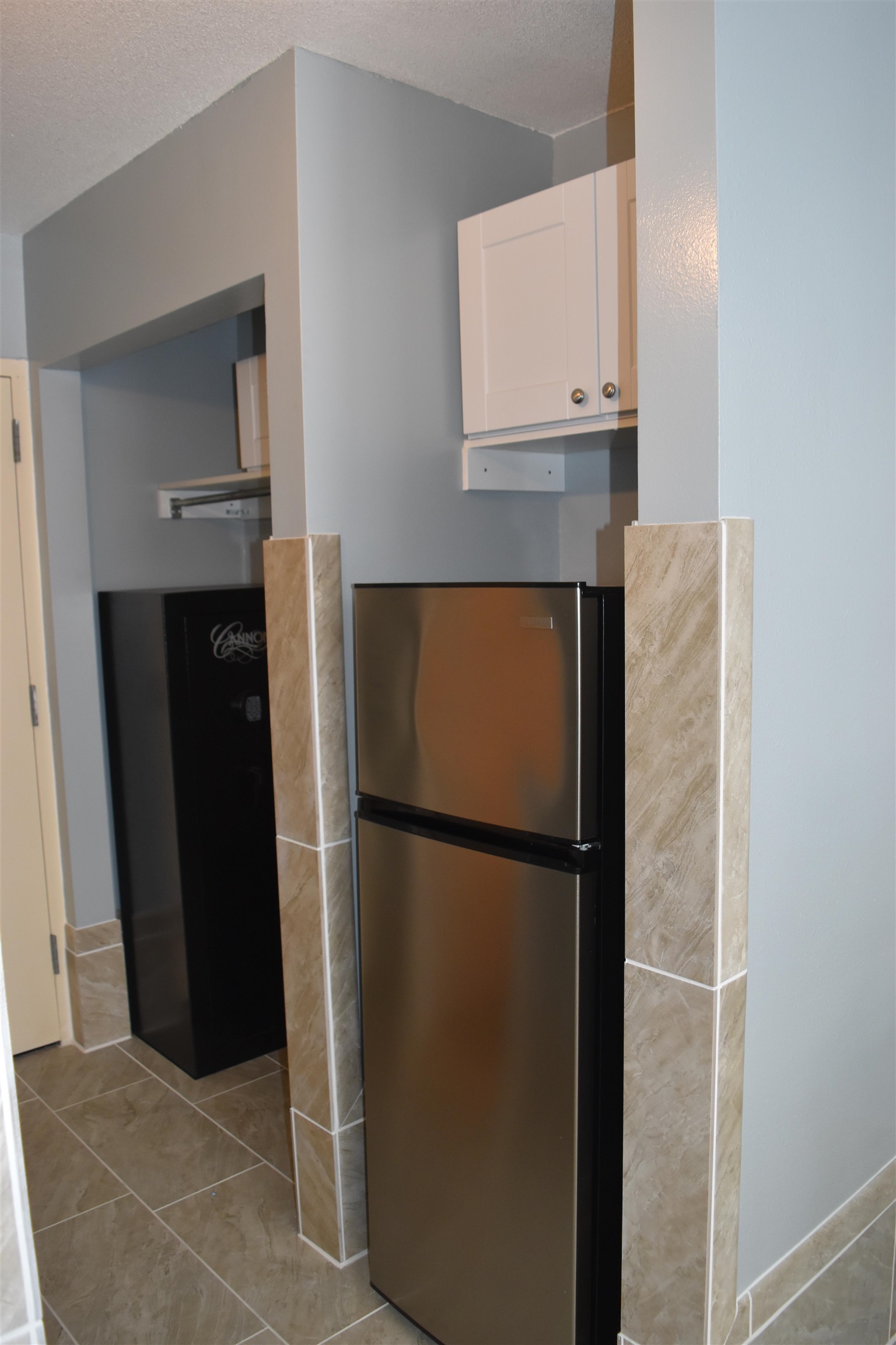1501 South Ocean Boulevard, Unit 910 Myrtle Beach, SC 29577 - Photo 8 of 31 Kitchen featuring freestanding refrigerator, white cabinets, a textured ceiling, and light tile patterned flooring