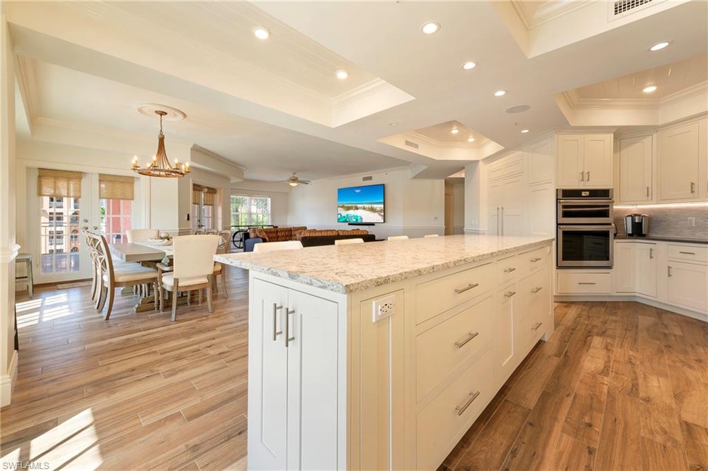 451 Bayfront Place, Unit 5407 Naples, FL 34102 - Photo 38 of 38 Kitchen with ornamental molding, a tray ceiling, a kitchen island, a chandelier, and open floor plan