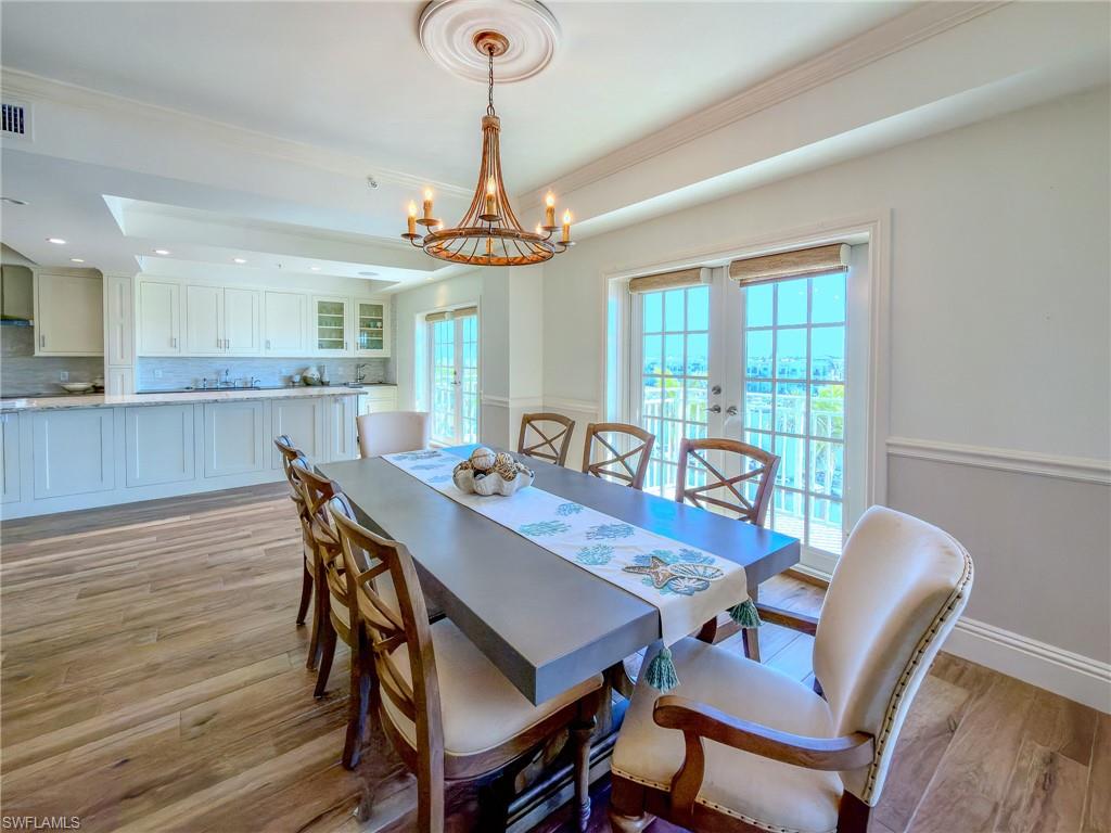 451 Bayfront Place, Unit 5407 Naples, FL 34102 - Photo 21 of 45 Dining space with light wood-style floors, french doors, suspended lighting, a raised ceiling, and healthy amount of natural light