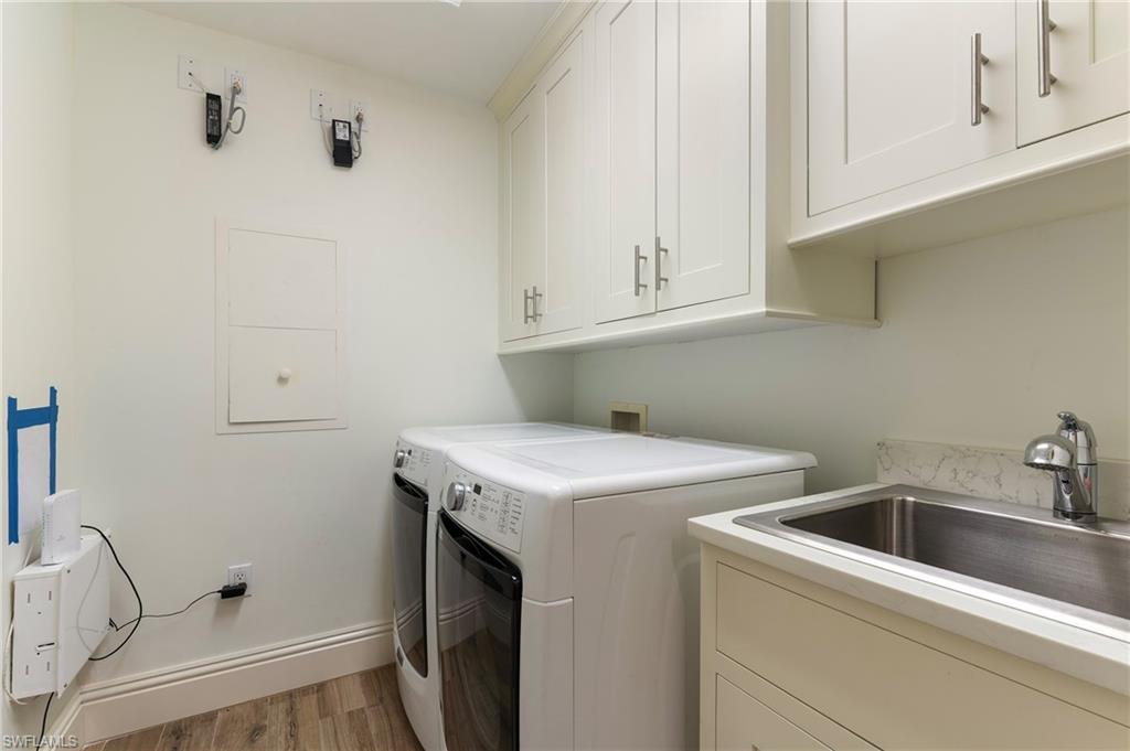 451 Bayfront Place, Unit 5407 Naples, FL 34102 - Photo 28 of 38 Laundry room with light wood-style flooring, independent washer and dryer, and cabinet space
