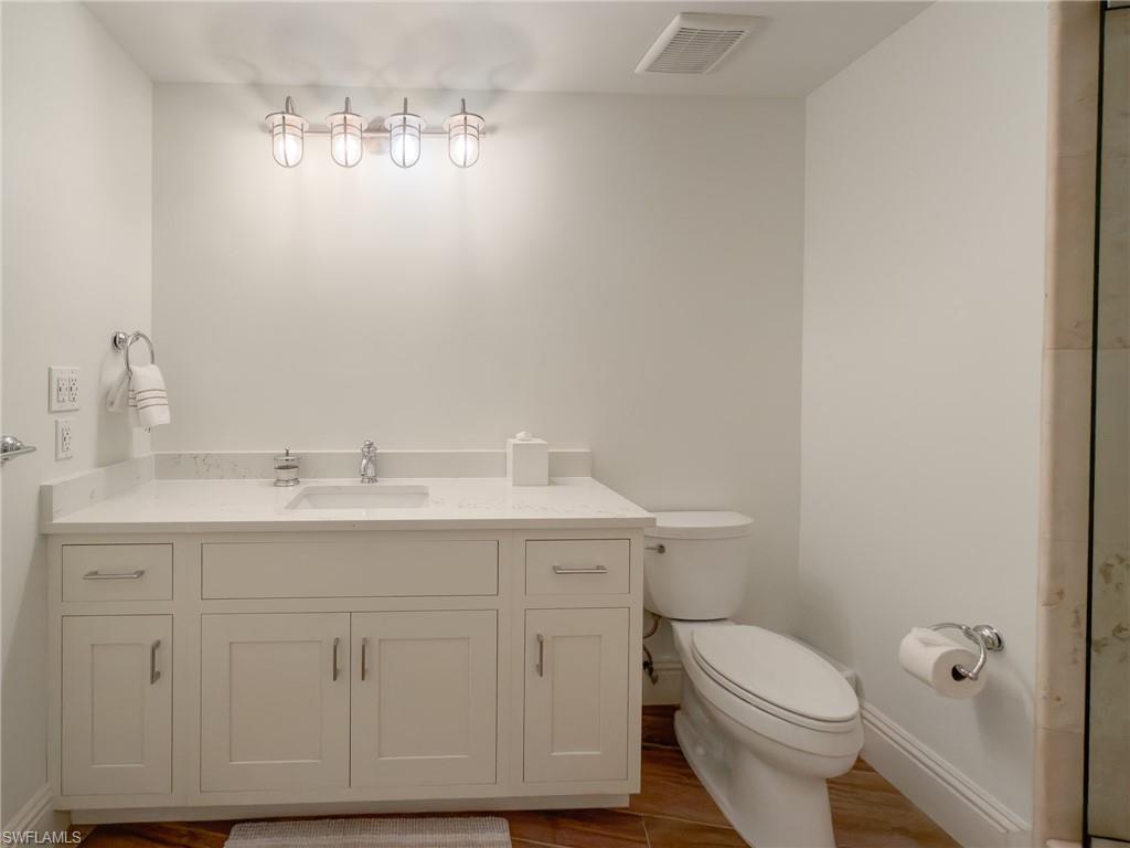 451 Bayfront Place, Unit 5407 Naples, FL 34102 - Photo 29 of 41 a bathroom with a sink a toilet and mirror