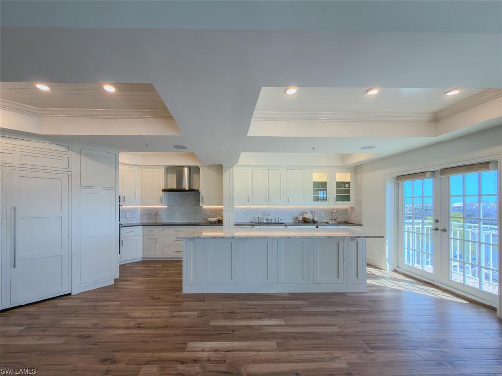 451 Bayfront Place, Unit 5407 Naples, FL 34102 - Photo 3 of 45 Kitchen with a raised ceiling, white cabinetry, ornamental molding, decorative backsplash, and dark wood-type flooring