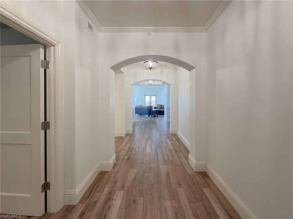451 Bayfront Place, Unit 5407 Naples, FL 34102 - Photo 34 of 45 Corridor featuring crown molding, light wood-type flooring, and arched walkways