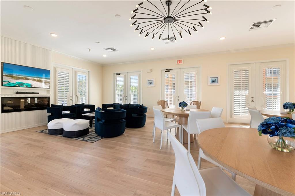 451 Bayfront Place, Unit 5407 Naples, FL 34102 - Photo 41 of 45 Dining room featuring french doors, light wood-type flooring, a glass covered fireplace, ornamental molding, and recessed lighting