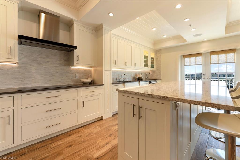 451 Bayfront Place, Unit 5407 Naples, FL 34102 - Photo 8 of 38 Kitchen featuring a breakfast bar area, light wood-type flooring, ornamental molding, recessed lighting, and backsplash