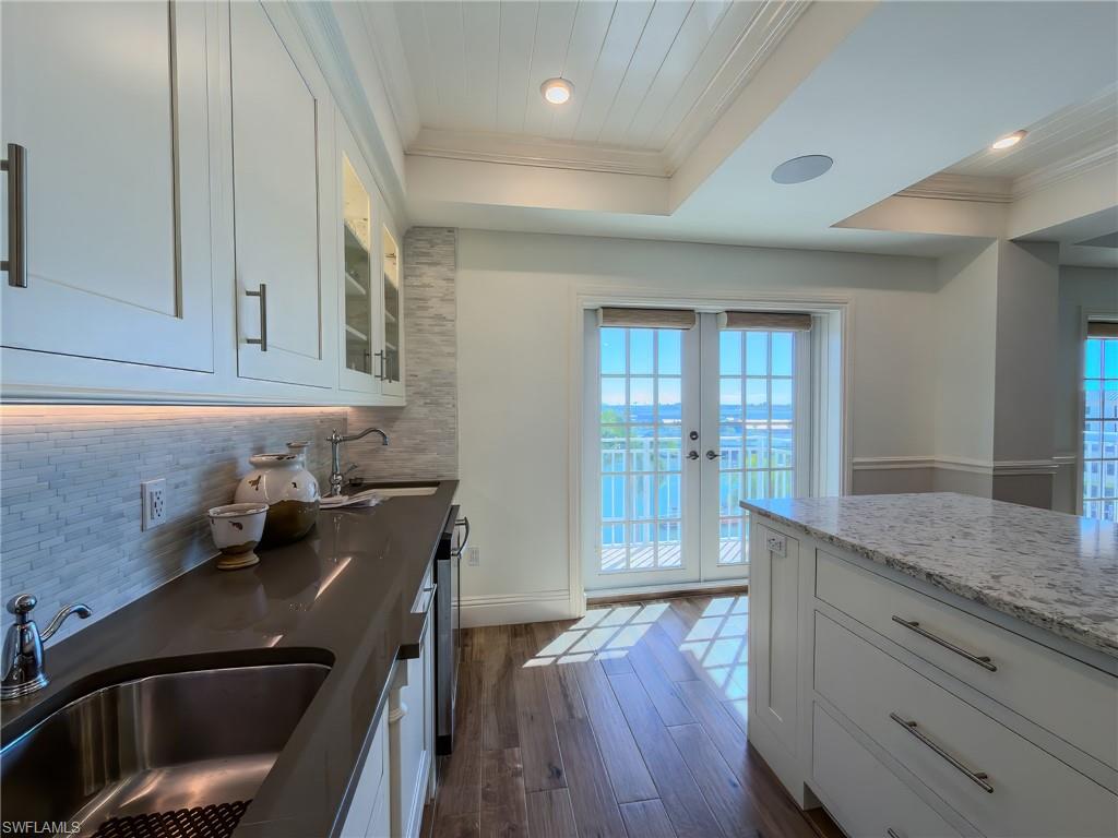 451 Bayfront Place, Unit 5407 Naples, FL 34102 - Photo 8 of 45 Kitchen with white cabinetry, dark wood-type flooring, french doors, ornamental molding, and dark stone counters