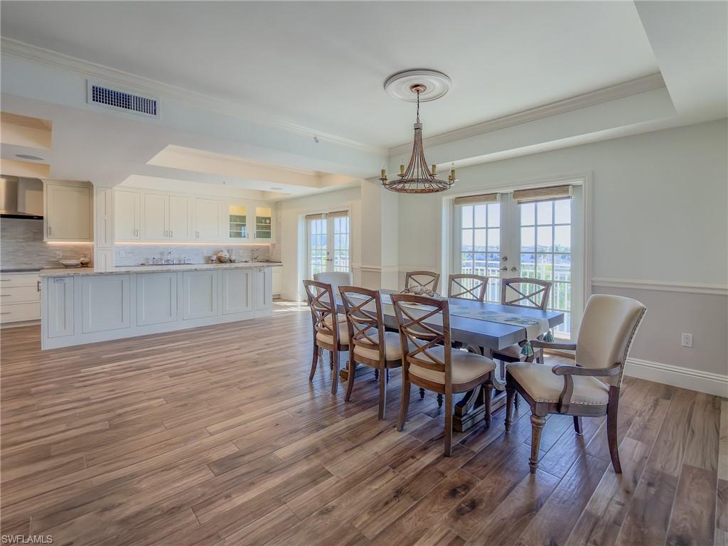 451 Bayfront Place, Unit 5407 Naples, FL 34102 - Photo 9 of 45 Dining space featuring light wood-type flooring, a raised ceiling, hanging lights, french doors, and crown molding