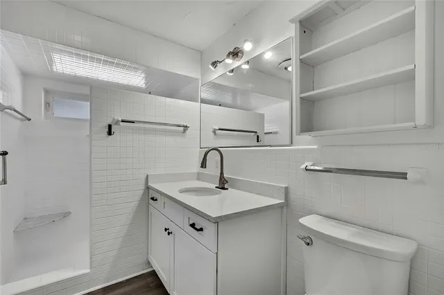 a bathroom with a sink a toilet and shower