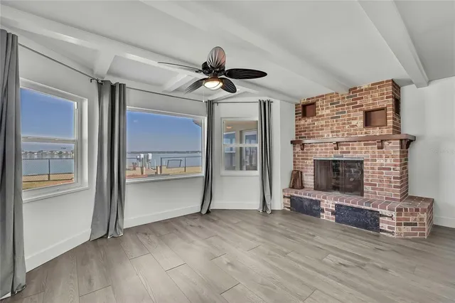 a view of an empty room with a fireplace and window