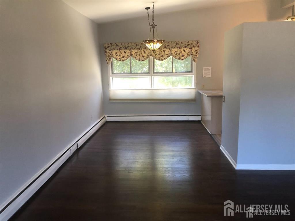 27 Mill Road Edison, NJ 08817 - Photo 6 of 17 an empty room with wooden floor and windows