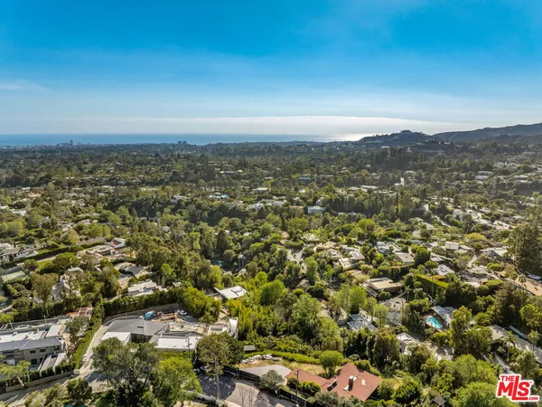 an aerial view of residential houses with city view