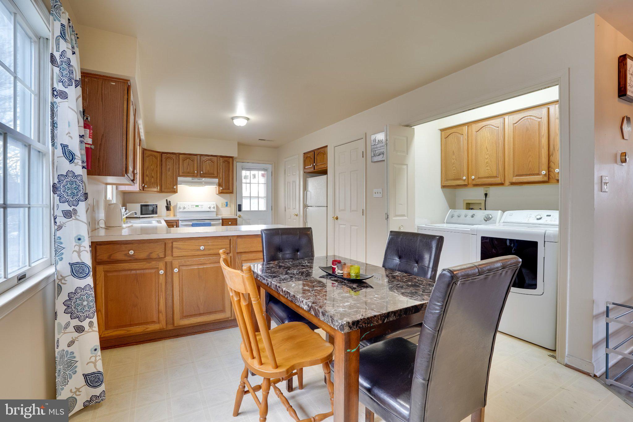 713-715 Medway Road Hagerstown, MD 21740 - Photo 23 of 43 a kitchen with granite countertop a table chairs a sink dishwasher stove and microwave with wooden floor